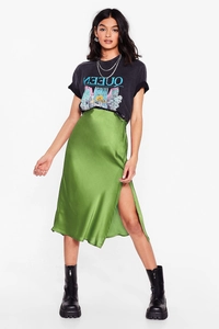 Detail of emerald green satin midi skirt featuring a high side slit and smooth fabric