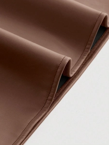 Close-up of brown PU leather fabric with litchi grain texture and neat stitching details
