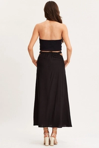 Detail of high waist elastic band and side cut-out on black maxi vacation skirt