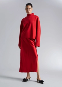 Detail view of red satin midi skirt with side slit and elegant silk-like texture