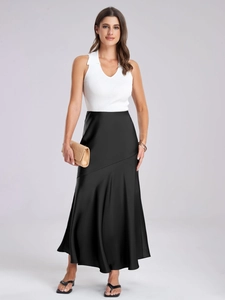 Détail de la jupe en satin noir avec coutures diagonales et un drapé fluide très élégant