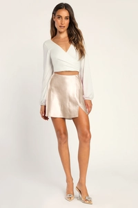 Détail d'une jupe en satin champagne à taille haute avec fente latérale et texture soyeuse
