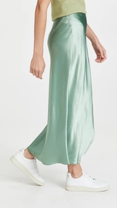Detailed view of sage green satin maxi skirt showing high-waisted cut and silky texture