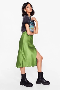 Detail view of grass green satin midi skirt showing side slit and smooth fabric drape