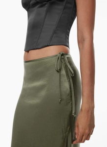 Detailed view of the dark green satin high-waisted skirt with side tie and slit details