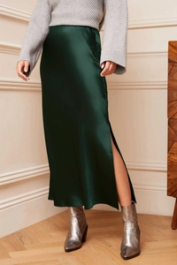 Detail view of dark green satin skirt with a high waist and side slit in elegant fabric