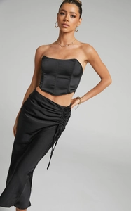 Detail of elegant black satin maxi skirt featuring side drawstring and ruched texture details