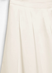 Detailed view of cream high waist pleated skirt featuring elegant woven fabric texture