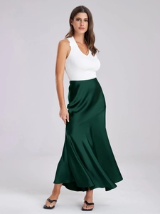 Détail d'une jupe longue élégante en satin vert forêt à taille haute et texture soie lisse