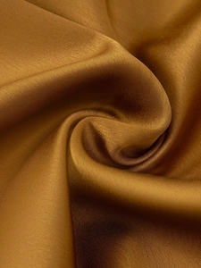 Gros plan sur la texture satinée marron avec un brillant élégant et un drapé soyeux