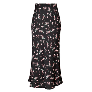 Close-up of black satin high-waisted skirt featuring delicate pink floral prints and side slit