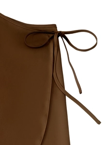 Detailed view of high-waist satin wrap skirt showing the tie-up waist and fabric texture