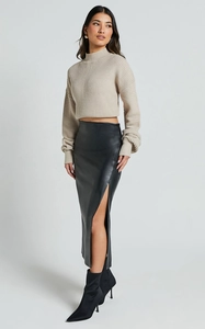 Vue détaillée de la jupe noire en similicuir à taille haute avec une fente latérale chic