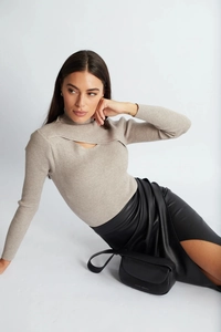 Detail of high waist black PU leather skirt with side slit and ruched design for women