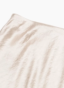 Macro detail of champagne satin skirt showing silk texture and high-quality stitching