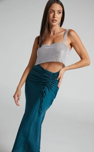 Detail of high-waist ruched satin skirt with drawstrings and dark green silky texture