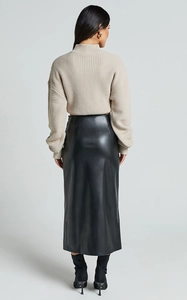 Vue arrière d'une jupe fendue en similicuir noir à taille haute et pull à col roulé côtelé