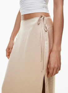 Detail of high-waisted champagne satin wrap skirt with side slit and waist tie