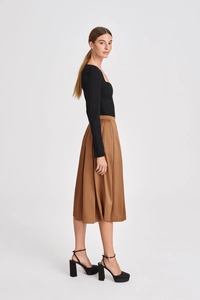 Detail view of high-waist pleated midi skirt with elegant satin finish and fluid drape