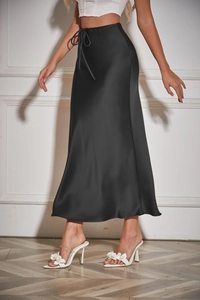 Detail of high waist satin black midi skirt featuring drawstring tie and glossy fabric texture