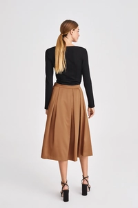 Detail of high waist pleated skirt in khaki and black long sleeve backless top set