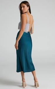Detailed close-up of dark teal satin midi skirt texture and elegant side ruched design