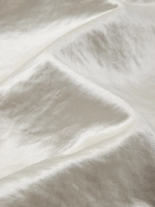 Detailed macro view of the premium textured satin fabric with soft pearlescent sheen