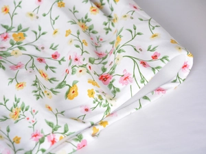 Detail shot of the floral print acetate fabric with small yellow and pink flowers