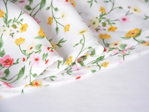 Detailed macro shot of floral satin fabric with fine stitching and soft draping texture