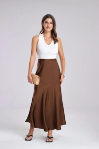 Détail de l'élégante jupe midi en satin marron portée avec un haut blanc côtelé