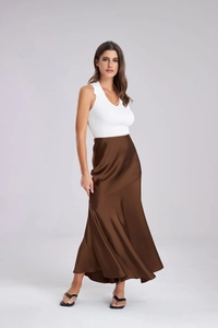 Détail de la jupe longue en satin chocolat élégante et du haut blanc côtelé à col en V