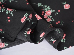 Macro shot of satin skirt edge showing fine stitching and pink floral pattern