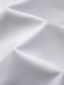 Close-up of white textile fabric texture showing detailed twill weave and soft folds