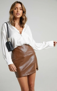 Close-up of high-waisted brown PU leather skirt with a stylish side slit detail