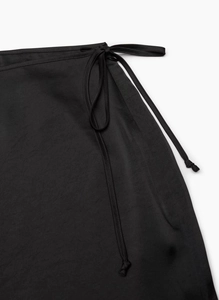 Detail of high waist satin skirt showing tie-up waist design and premium fabric texture