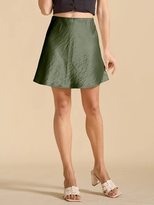 Texture detail of dark green satin mini skirt with elegant glossy fabric finish
