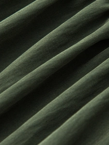 Detailed macro view of olive green twill fabric texture on high waisted maxi skirt
