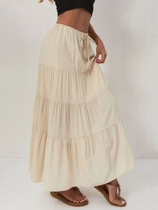 Détail d'une jupe longue beige à taille haute élastique et design à plusieurs couches