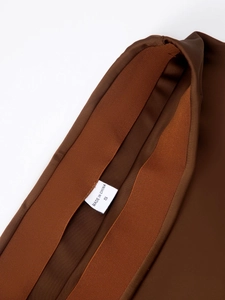 Gros plan détaillé de la taille élastique d'une jupe en satin marron avec étiquette S