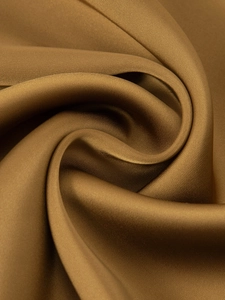 Detailed macro shot of elegant golden bronze satin fabric with smooth silky texture