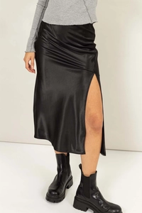 Détail de la jupe midi en satin noir avec taille haute et fente latérale élégante