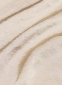 Close-up of champagne satin fabric showing high-gloss texture and soft silk pleats