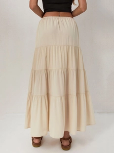 Détail du design à volants et de la taille haute de cette jupe longue en coton beige