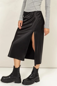 Gros plan sur une jupe midi en satin noir avec fente latérale haute et fini soyeux