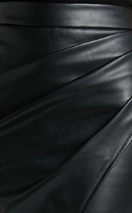 Detailed macro view of the ruched diagonal pleats on this black PU leather pencil skirt