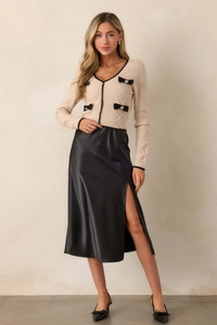 Détail de la jupe midi en satin noir à taille haute avec fente latérale et texture lisse