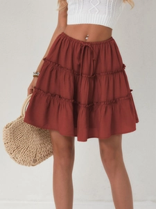 Detail of bohemian tiered rust mini skirt with adjustable drawstring waist and ruffled layers