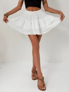Detail of white layered skirt featuring elastic waistband and delicate polka dot texture