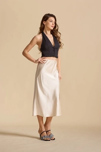 Détail d'une jupe midi en satin champagne à taille haute avec une finition en soie élégante