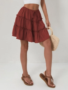 Detail of rust red tiered mini skirt showing elastic drawstring waist and layered fabric